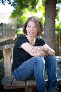 Photo of Jamie Mayer sitting and smiling