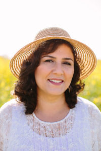 Photo of Rosa Daneshvar smiling and wearing a hat